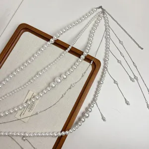Detailaufnahme der mehrlagigen Perlen-Taillenkette mit Metallketten und Quasten.