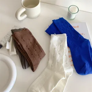 Detailed view of distressed cotton slouch socks in vibrant blue, white, brown, and grey colors.
