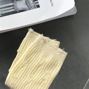Close-up detail of yellow distressed knit socks showing unique cutout texture and ribbed style.