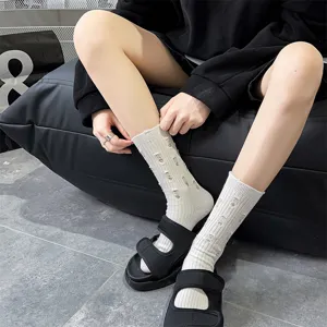 Detail shot of women's distressed cotton crew socks featuring a trendy ripped design for wear.