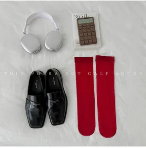 Vue détaillée de chaussettes mi-mollet rouges transparentes à pois dans un style plat.