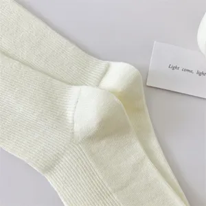 Close-up of solid color women's ribbed cotton mid-tube socks, soft fabric texture detail view.