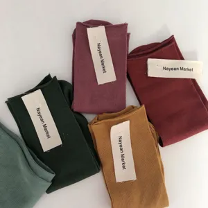 Detailed view of colorful rolled-edge cotton mid-tube socks in various candy shades, soft fabric.