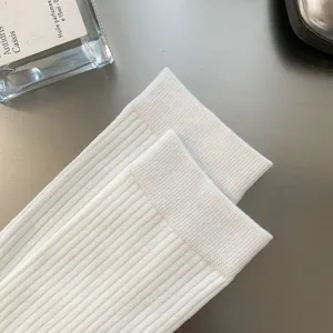 Gros plan détaillé de chaussettes montantes blanches côtelées en tricot avec texture douce.