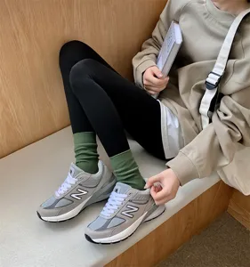 Detail shot of stylish green ribbed cotton mid-tube socks paired with casual retro sneakers.