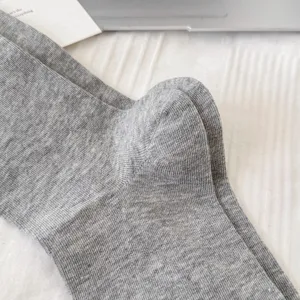Dettaglio calzino in cotone a coste grigio, primo piano della trama morbida e traspirante.
