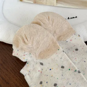 Primer plano detallado de calcetines de mujer con lunares coloridos y talón de contraste.