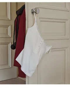 Detail shot of a white ribbed lace-trim camisole with henley buttons and built-in cups.