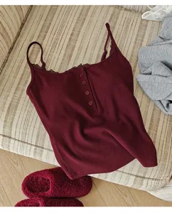Detailed shot of the burgundy ribbed camisole with lace trim and henley button design.