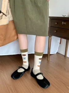 Gros plan détaillé de chaussettes à motif de chien mignon portées avec des chaussures tabi.