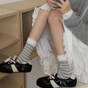 Close-up detail of soft striped mid-calf socks paired with stylish casual shoes for daily wear.
