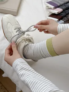 Autumn striped mid-tube socks women cotton casual socks paired with sneakers detailed view.