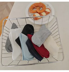 Detail view of cozy knit crew socks in assorted colors neatly organized in a stylish wire basket.