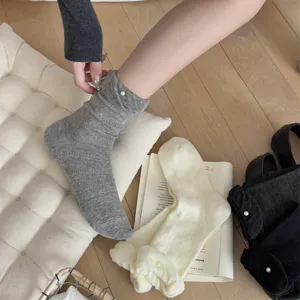 Vista dettagliata di calzini in cotone da donna con perla elegante e polsino arricciato.