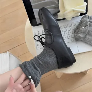 Vista di dettaglio di calzini in cotone da donna con decorazione di perle e scarpe.