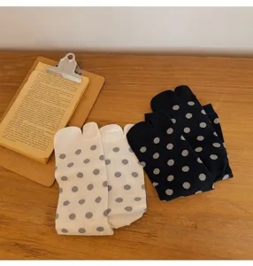 Detailed closeup of cute polka dot split toe socks in classic black and white colors.