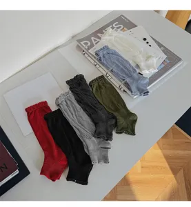 Gros plan de jambières unies à volants, tissu en coton doux, style superposé tendance.