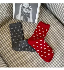Detail shot of colorful cotton mid-tube women socks with large polka dots in grey and red.