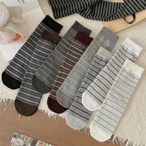 Close-up detail of multi-color striped mid-calf women socks in cozy cotton lifestyle flat lay.
