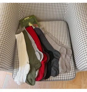 Vista dettagliata di calze lunghe in maglia da donna con trama a trecce, colori vari.