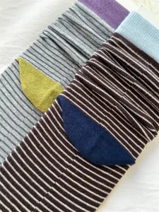 Close-up detail of women's colorful striped stack socks featuring contrast color patches.