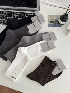 Detailaufnahme gerippter, einfarbiger Baumwoll-Herrensocken in klassischem Design auf dem Tisch.