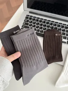 Nahaufnahme von gerippten Herren-Baumwollsocken in Dunkelgrau und Braun mit feiner Strickstruktur.
