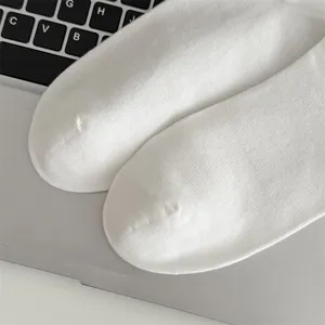 Detailansicht schlichter weißer Baumwollsocken für Herren mit weicher Rippenstruktur.