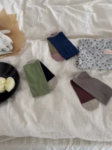 Close-up of colorful colorblock mid-tube cotton socks, styled flat lay with aesthetic props.