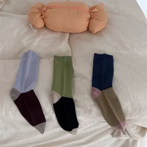 Colorblocked mid-calf cotton socks with trendy contrasting hues for cozy winter daily wear.