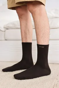 Nahaufnahme brauner Rippstrick-Herrensocken aus Baumwolle mit bequemem hochelastischem Bündchen.