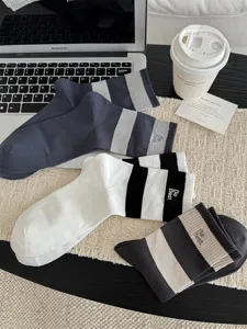 Detailaufnahme gestreifter Herren Freizeitsocken mit feiner Buchstabenstickerei und elastischem Bund.
