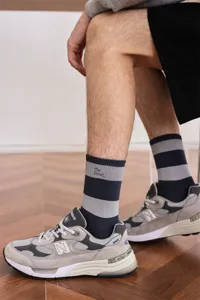 Detailaufnahme von Freizeitsocken für Herren mit Streifen und Stickerei im Sneaker-Look.