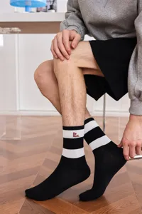 Nahaufnahme von schwarz-weißen, gestreiften Herren-Wadenstrümpfen mit stylischer Stickerei.
