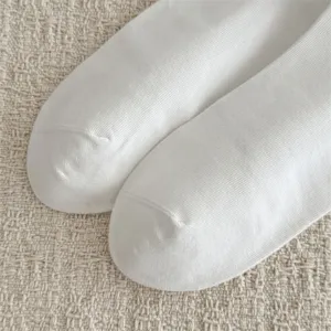Nahaufnahme hochwertiger weißer Herrensocken mit weicher Baumwollstruktur und feinem Rippbündchen.
