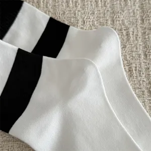 Nahaufnahme klassischer schwarz-weißer gestreifter Baumwoll-Mittelsocken, weiche Textur.