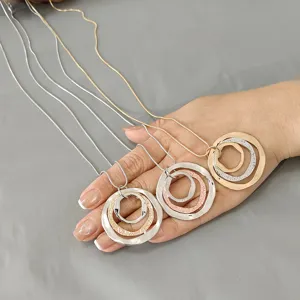 Nahaufnahme der verschachtelten Mehrring-Anhänger-Langekette mit elegantem Metallfinish.