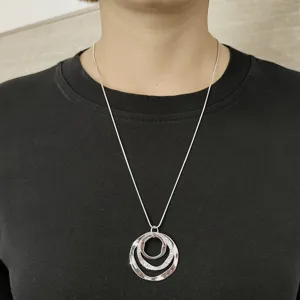 Detailansicht der eleganten Mehrring-Anhänger-Halskette mit feiner, glänzender Metallstruktur.