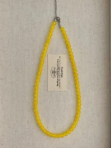 Dettaglio collana di perle in calcedonio giallo artigianale, stile retro minimalista estate