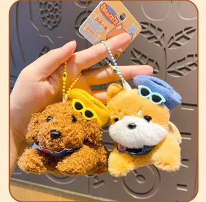 Cute plush dog keychain detail showing soft texture, miniature sunglasses, and cap accessories.