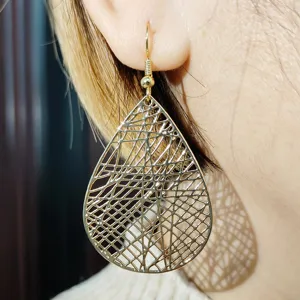 Orecchini pendenti a goccia in metallo dorato, design geometrico traforato stile vintage.