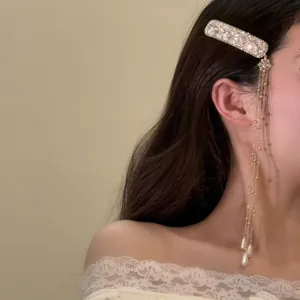 Detailopname van de elegante strass kwast haarklem met delicate hangende parels.