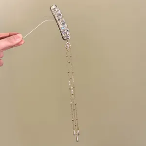 Gedetailleerd overzicht van strass kwast haarspeld met sprankelende kristallen en fijne kettingen.