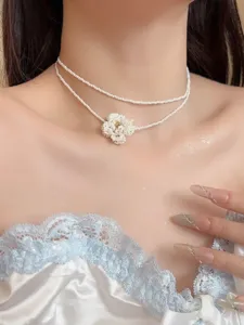 Exquisite doppelschichtige weiße Perlenperlen Halskette mit Blumenanhänger Nahaufnahme Detail.