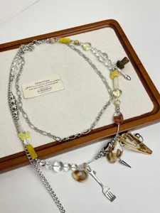 Vue détaillée de la chaîne de taille double avec coquillages, perles et pendentifs originaux.