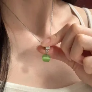 Delicate collier pendentif pomme vert menthe avec chaîne argentée, style frais.