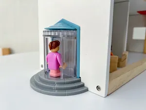 Dettaglio giocattolo casa delle bambole in legno nordico con porta girevole e graziosa statuetta.