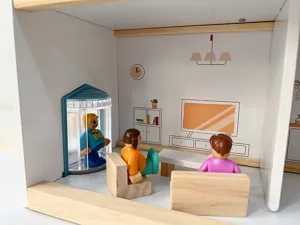 Dettaglio soggiorno casa bambole legno nordico, mobili in miniatura e simpatici personaggi.