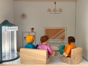 Dettaglio soggiorno casa delle bambole in legno nordico giocattolo con mini figurine.