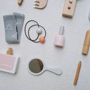 Wooden makeup toy set detail showing charming miniature perfume mirror and lipstick accessories.